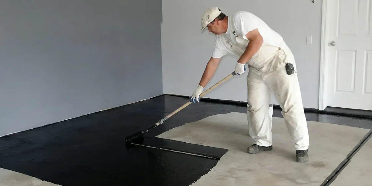 basement waterproofing professional applying waterproof coating to protect a basement floor in Chandler, AZ